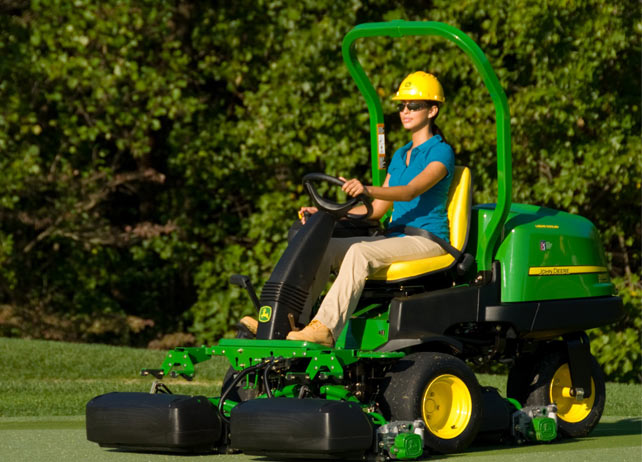 Worker uses 2500E E-Cut Hybrid Gas mower to mow golf course green