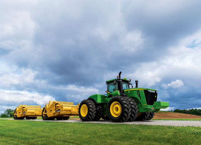 9620R Scraper Special Tractor with scraper attachments driving down a ...