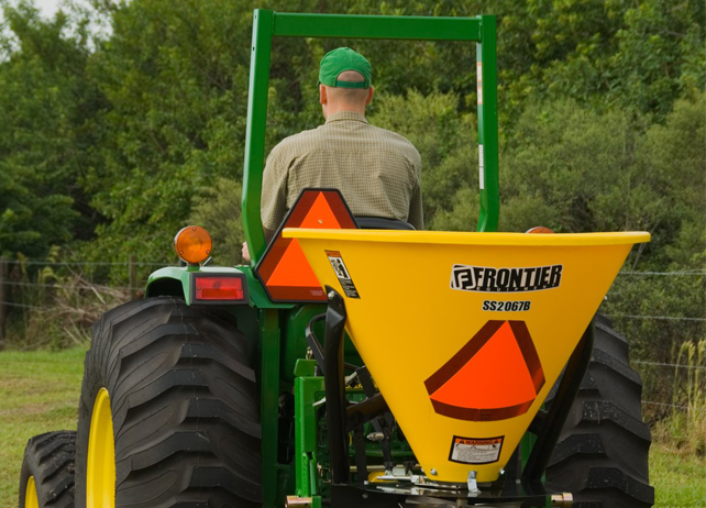 man driving a John Deere tractor with SS20B Series Broadcast Spreader ...