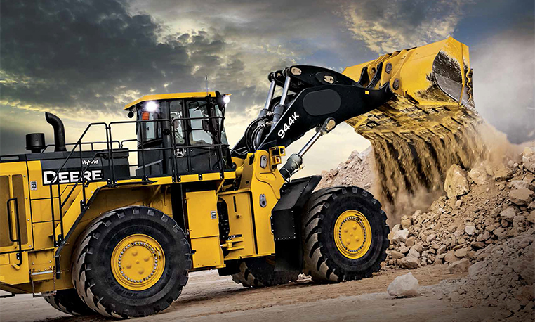 The John Deere 944K Wheel Loader unloads a bucket of rock