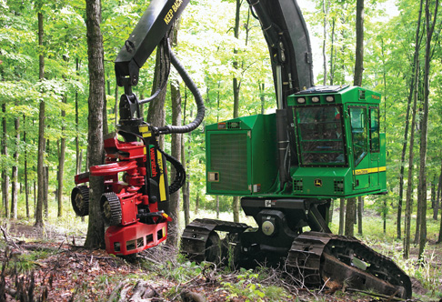 759JH Tracked Harvester cutting down a tree in a hilly forest