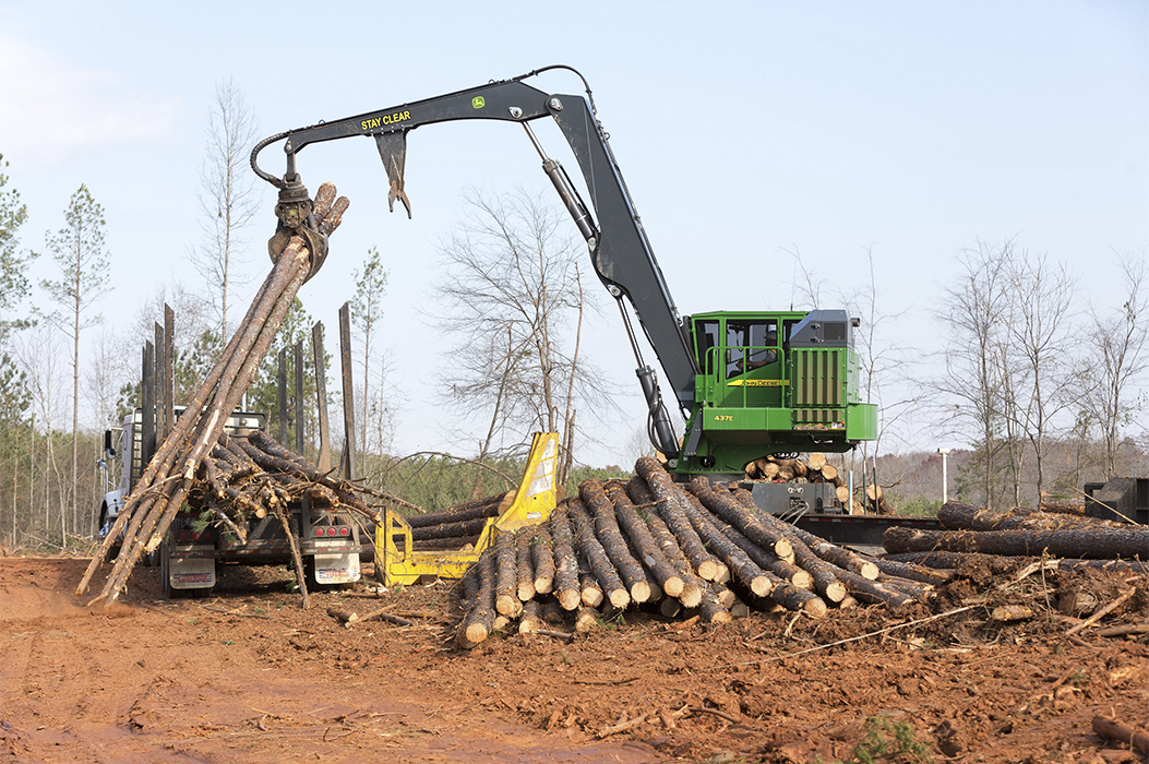 Right hand view of 437E Knuckleboom Loader delimbing logs