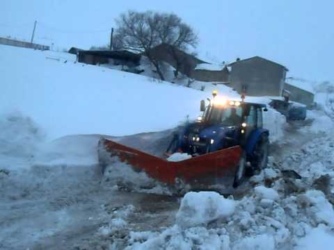 Lo spalatore libera il bobcat col trattore contro bobcat nella neve